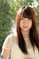 A young woman with long brown hair posing for a picture.