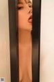 A naked woman sticking out her tongue in a mirror.