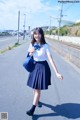 A woman in a school uniform is walking down the street.