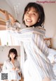 A woman in a blue and white striped shirt is posing on a bed.