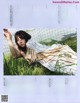 A woman laying in the grass in a magazine.