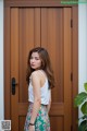 A woman standing in front of a wooden door.