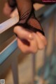 A close up of a person's hand in fishnet stockings.