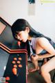 A woman sitting on top of a chair next to a video game console.